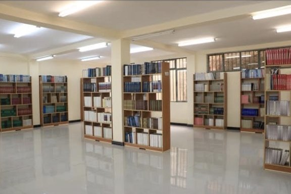 The bright main hall of the Sinen Lafto Community Library, lined with full bookshelves